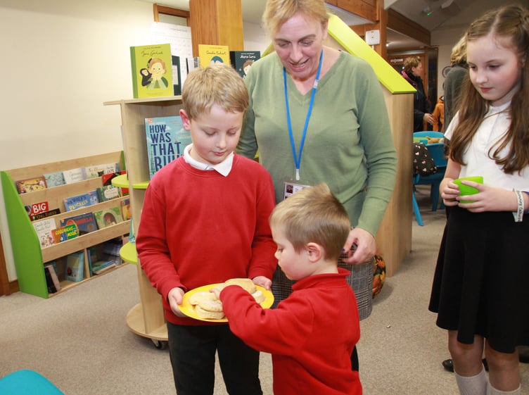 Teacher Amy Ahern oversees pupils serving canapés at the opening of a new library for Dulverton pupils. PHOTO: George Ody.