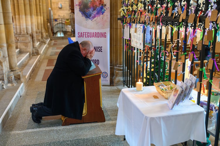 Bishop David prays at Truro Cathedral's LOUD Fence