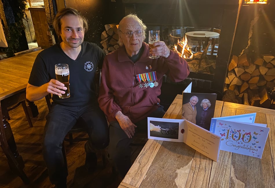 <p>Carl Dadson, landlord of The Nelson Arms in Castle Street, Farnham, has a drink with his grandfather Ed Nelson to celebrate his 100th birthday on December 16 </p>