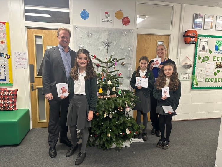 Left to right: MP Greg Stafford, winner of Christmas card competition Evelyn, runners up Ruby and Pinelopi, and Shottermill headteacher Kate Burns