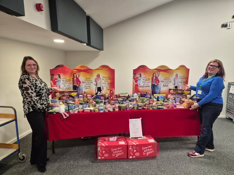 Sian Mills of Alton Foodbank and Macala Cooper of Slimming World in Alton with slimmers' donations to the foodbank, Alton Maltings Centre, December 18th 2024.