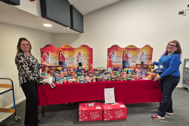 Sian Mills of Alton Foodbank and Macala Cooper of Slimming World in Alton with slimmers' donations to the foodbank, Alton Maltings Centre, December 18th 2024.