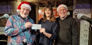 Musicians hand over pot of Christmas cash to Farnham charity