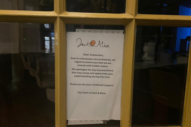 The sign in the window of Jack and Alice wine bar and restaurant.