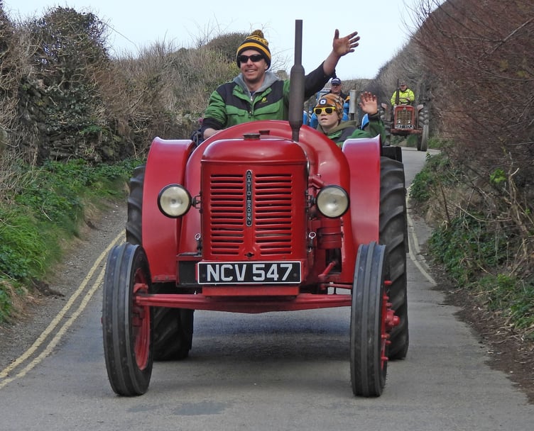 Giving a wave to the awaiting crowd at Port Gaverne are Dan Ward along with his son Alex on their David Brown vintage tractor (Picture: Adrian Jasper)