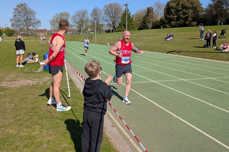 Men's captain Steve Armstrong is cheered on by his son Ethan and Joe Sykes as he approaches the finish