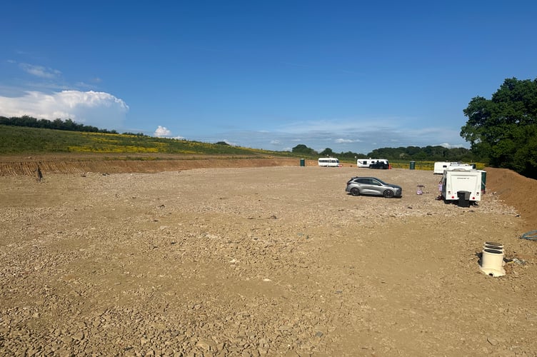 Caravans and construction equipment occupy a field near Lurgashall in the South Downs National Park.