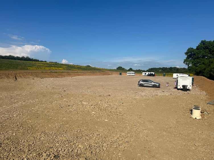 Caravans and construction equipment occupy a field near Lurgashall in the South Downs National Park.