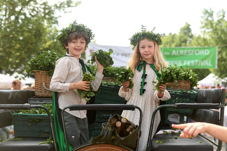 Toma Macpherson and Aoife McAllister, the Watercress King and Queen, throw freshly harvested watercress to the crowds at the Alresford Watercress Festival on May 18th, 2025
