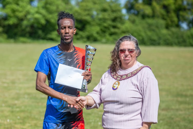 Race winner Abdinasir Elmi receives his trophy from 2024-25 Alton mayor Annette Eyre (Photo: Lee Ellis)