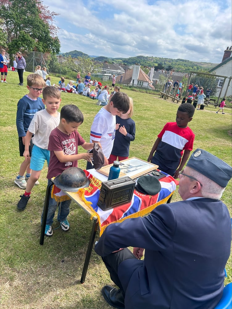 Local veteran Eddie Hill shows memorabilia to pupils in St Michael's First School, Minehead, for the 80th anniversary of VE Day.