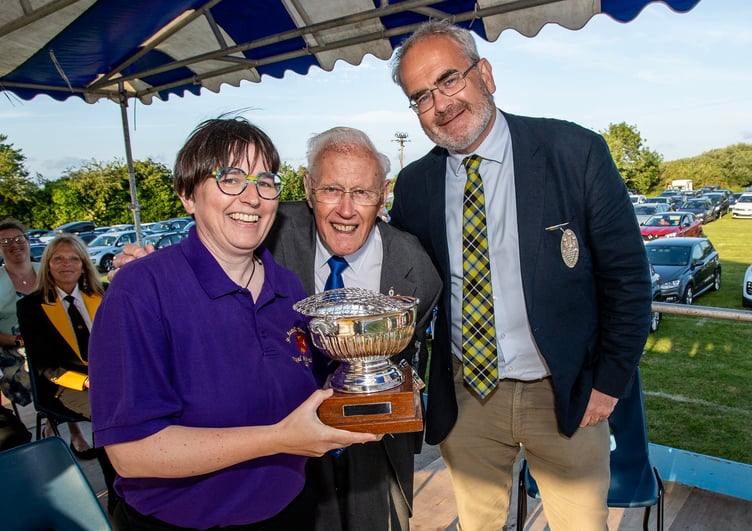 St Austell Town Band musical director Anna Minear collects a trophy from Graham Ball and Geraint Richards. (Picture: Paul Williams)