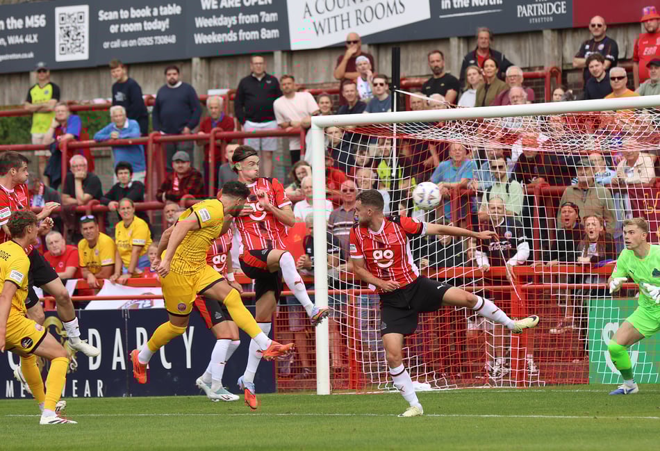 <p>Matt Penney heads home Aldershot Town's first goal at Altrincham (Photo: Ian Morsman)</p>