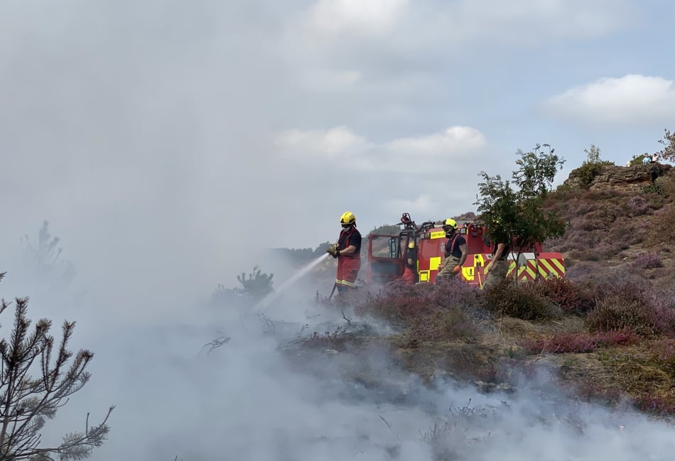 <p>Fire fighters work to put out wildfire caused by campfire on Churt Common</p>