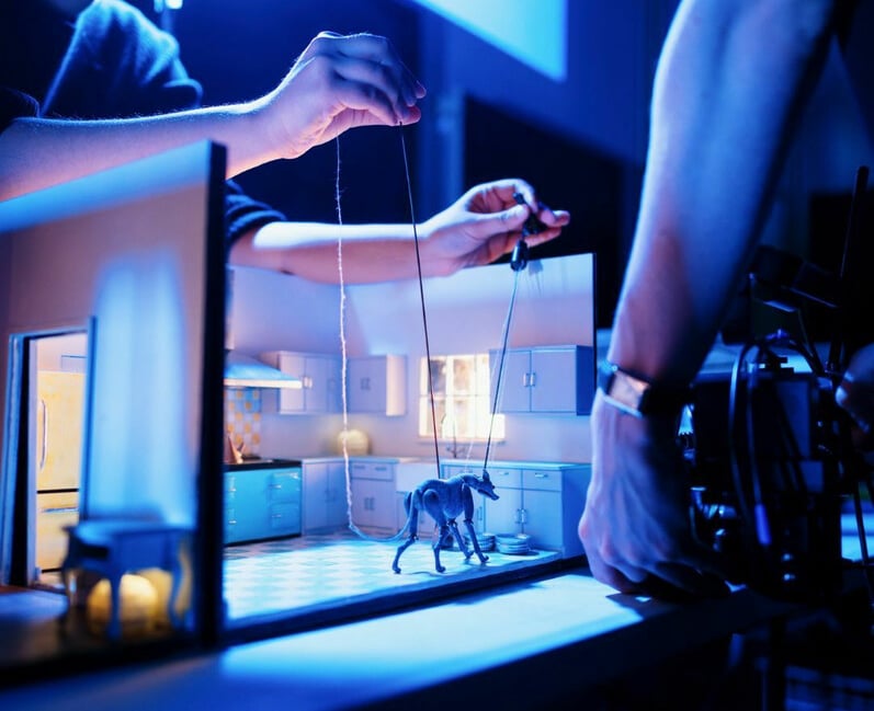 <p>How it's done - a little puppet dog in a tiny kitchen is animated, filmed and projected on to a big screen (Photo: Buzzcut Productions).</p>