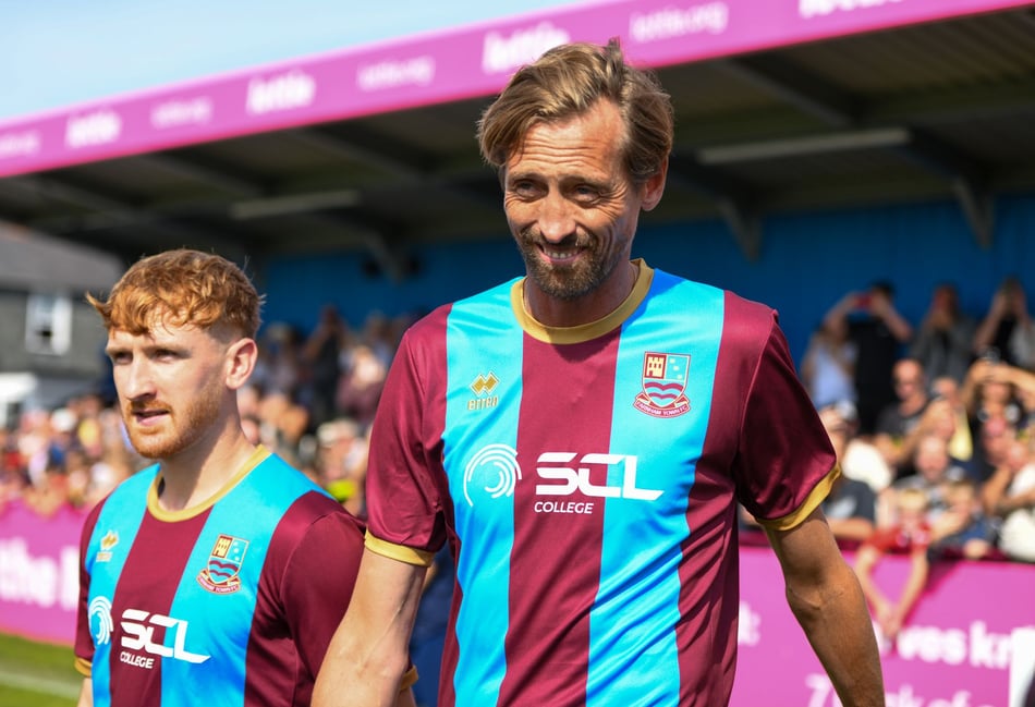 <p>Ex-England striker Peter Crouch enters The Memorial Ground's pitch as a Farnham Town mascot</p>