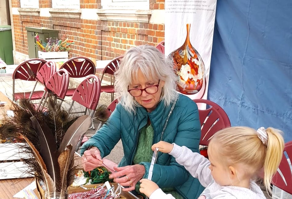 <p>Former Surrey Artist of the Year Jane Browne teaches branch weaving to a young student.</p>