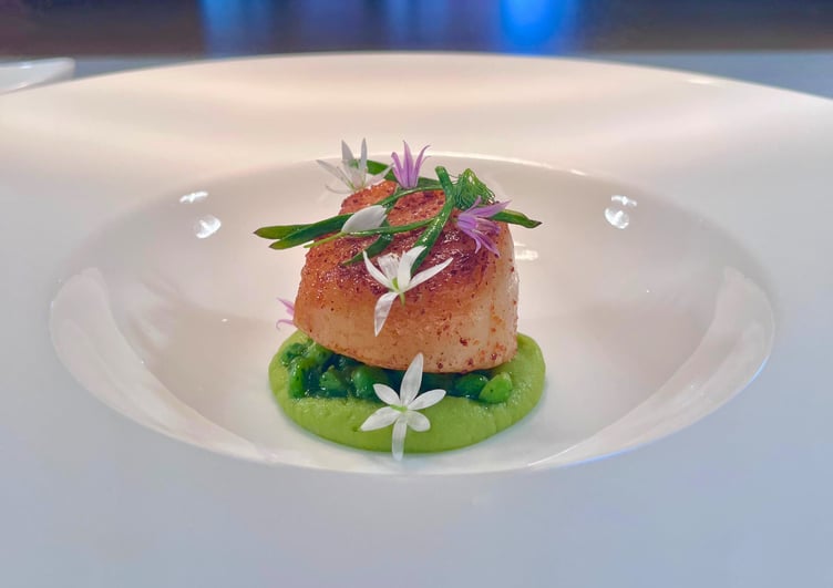 Scallop and pea with edible flowers to decorate.