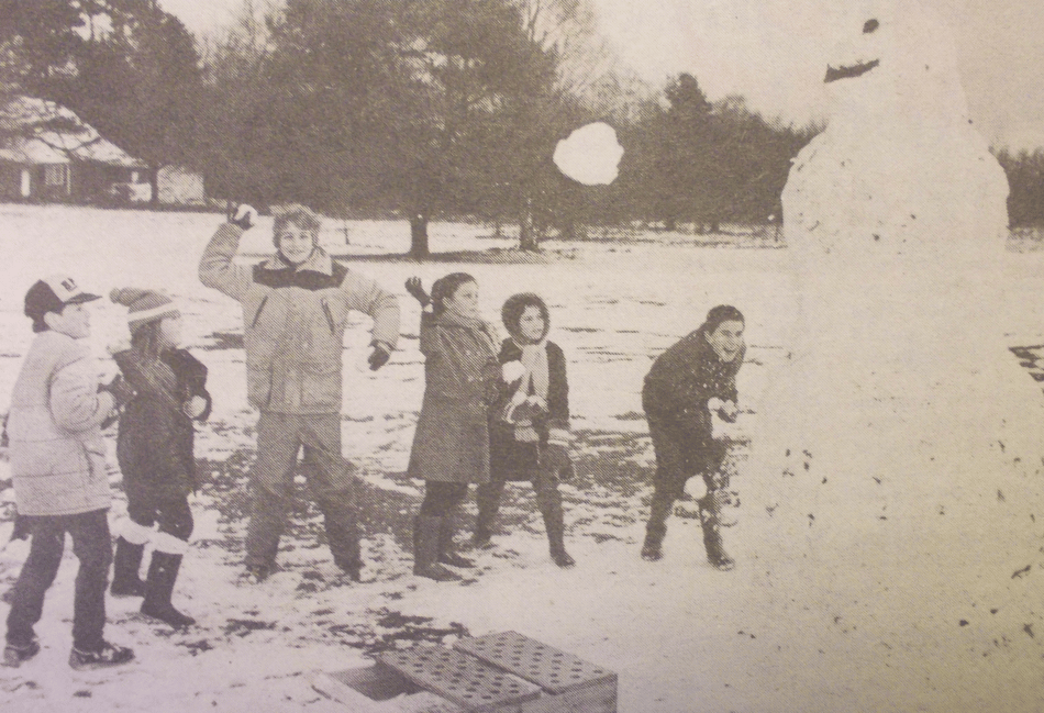 <p>Snowballing children take aim at a giant snowman on Butser Hill (Photo: East Hampshire Post).</p>