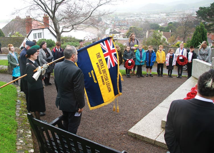 Minehead Royal British Legion's Emily Goodchild lowers the standard as two minutes of silence was observed at the town's North Hill war memorial. PHOTO: George Ody.