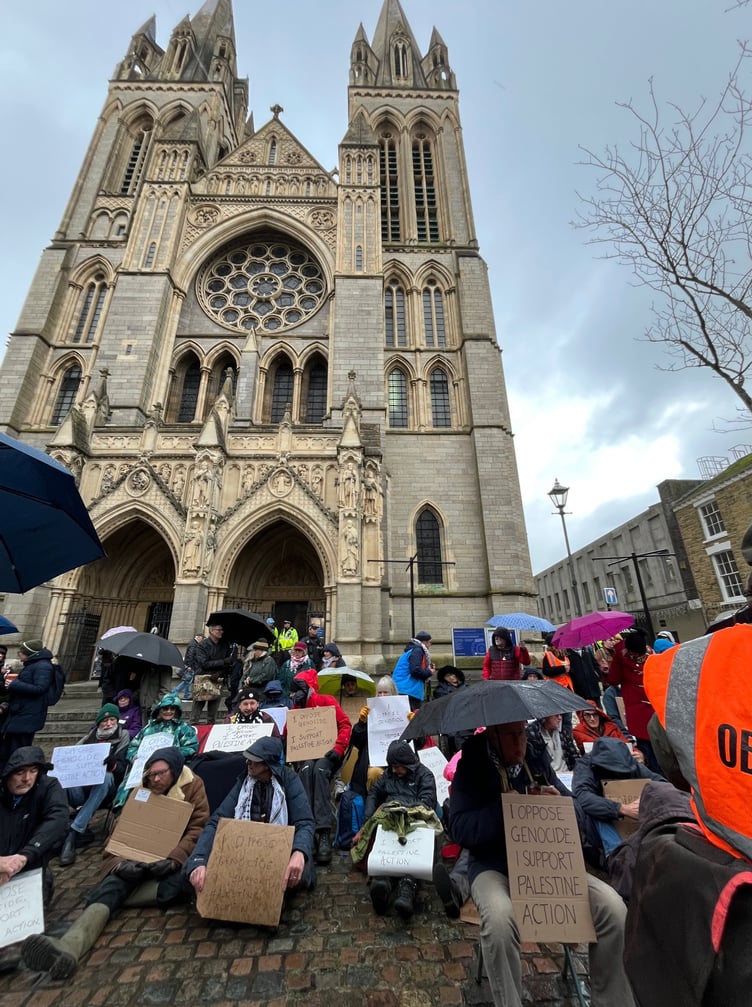 People huddled under umbrellas outside the Cathedral