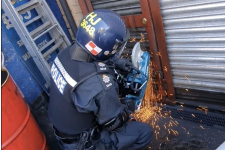 Surrey Police force entry into the crime gang's premises.