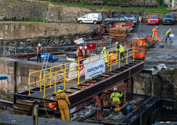 Workers lowering the new gate into position at Charlestown Harbour