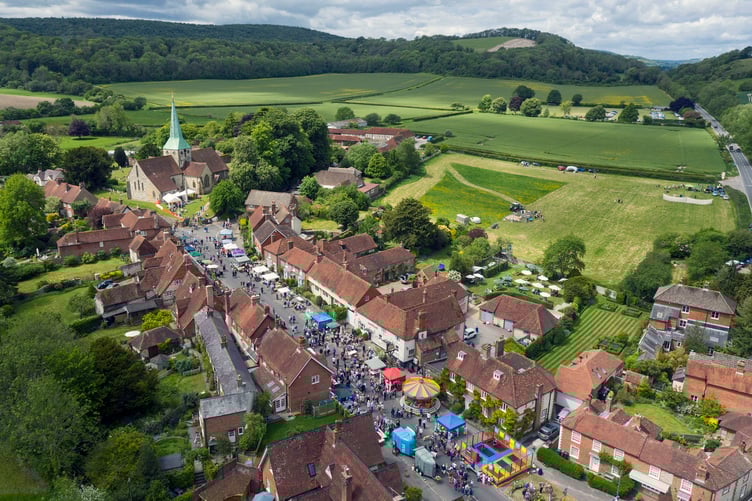 Villagers in the South Downs hamlet of South Harting in West Sussex gather for the Harting Festivities held on this bank holiday date each year. Sheep dog displays can be seen in the field on the right. Since 1880 the West Harting Old Club has its annual meeting on Whit Monday. The festivities started in 1961. The village is near the National Trust home of Uppark where HG wells often stayed.
The village was used in the 1950âs in a promotional film to show quintessential English life to the Commonwealth. NOTE: **All permissions have been granted for this drone image from CAA/Land owner and festival organisers.** Photograph By Chris Gorman/Big Ladder. 27th May 2019.