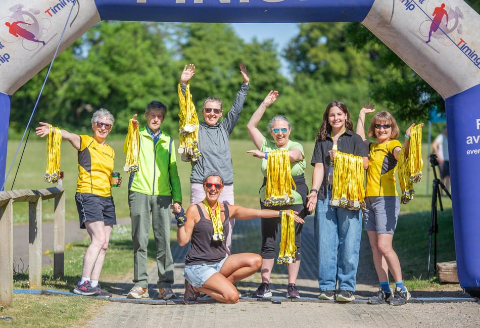 <p>Come and get them! Alton Runners show off the medals available to finishers in the Alton 10-Mile Race.</p>