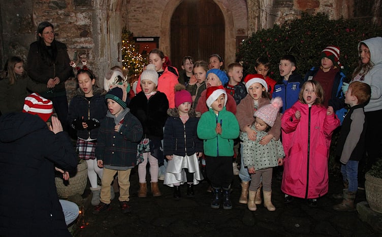 Porlock First School pupils sing carols outside St Dubricius Church as the village Christmas lights were switched on. PHOTO: George Ody.