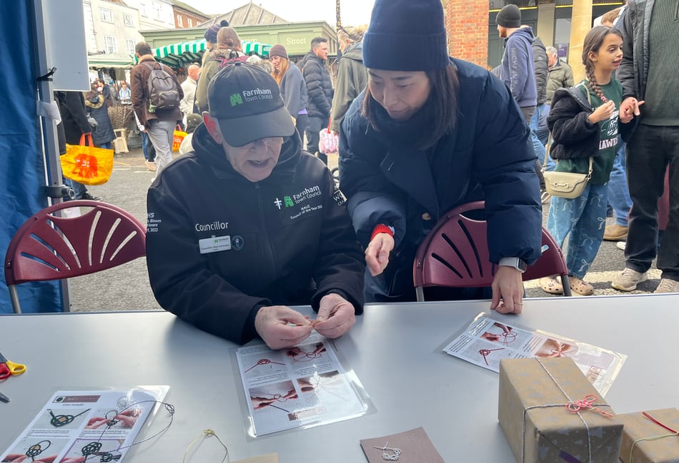 <p>Nao Fukumoto leads a Mizuhiki knotting workshop at the Farnham Christmas Market (Photo: New Ashgate Gallery).</p>