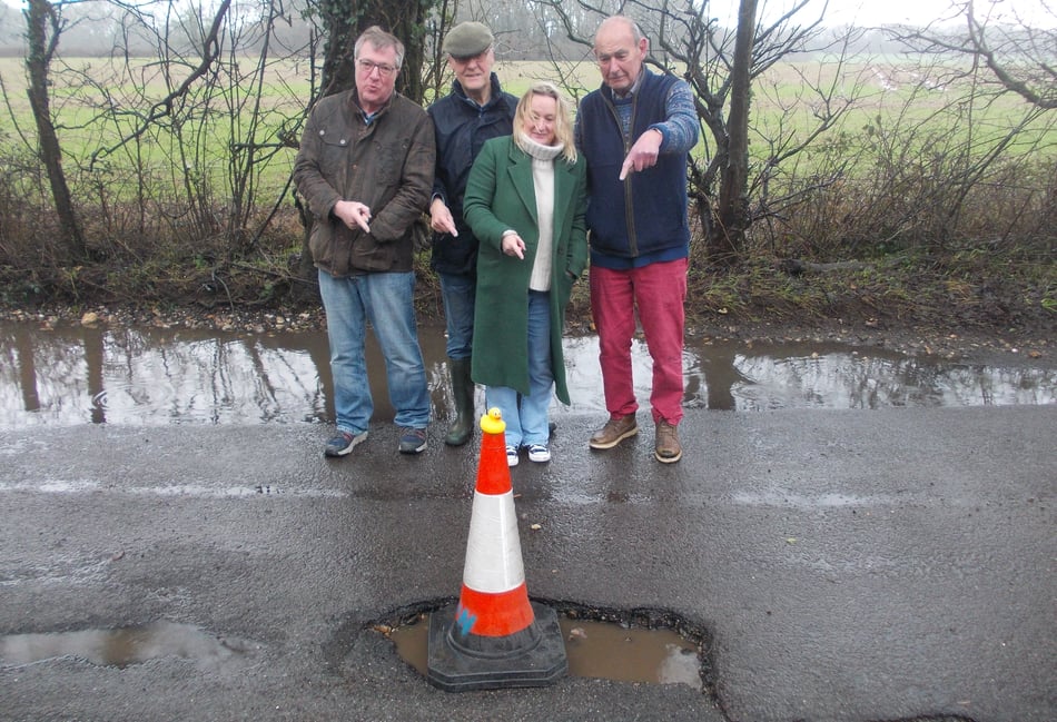 <p>Villagers point to one of the many potholes in the Wield to Medstead road.</p>