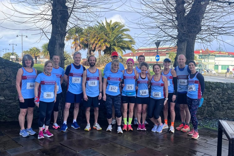 Farnham Runners pose in front of a palm tree in the sunshine before the Ryde ten-mile race