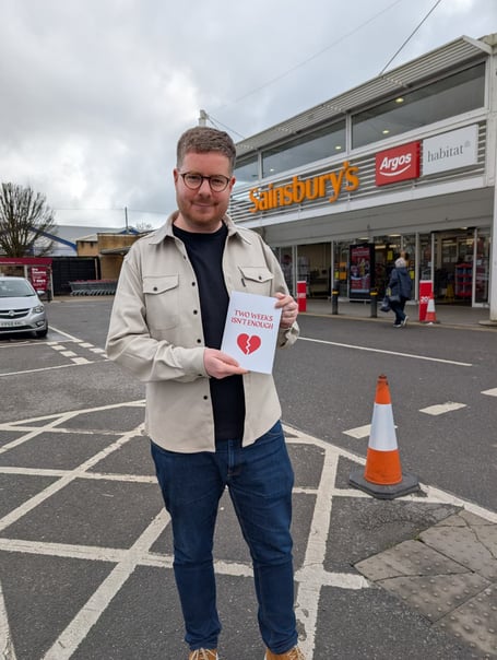 Andy Laird with his broken hearts card outside Sainsbury's supermarket in Farnham.