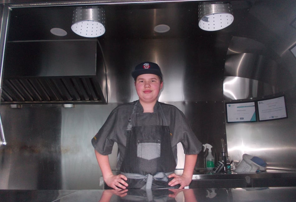 <p>Dexter Olejarka gets ready to cook on the Crane Feasts food truck.</p>