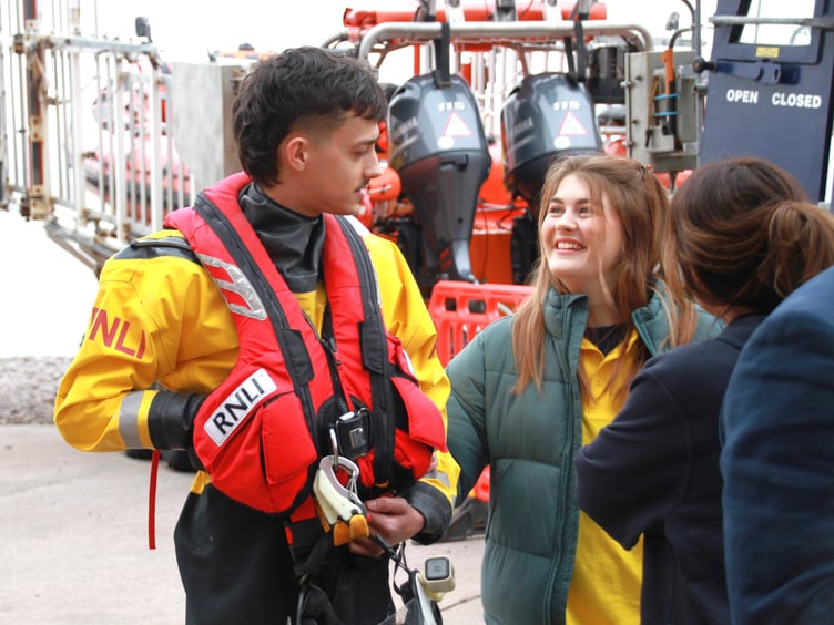 Harrison Webber, whose mother Raji is a lifeboat helm, demonstrating crew kit to visitors.