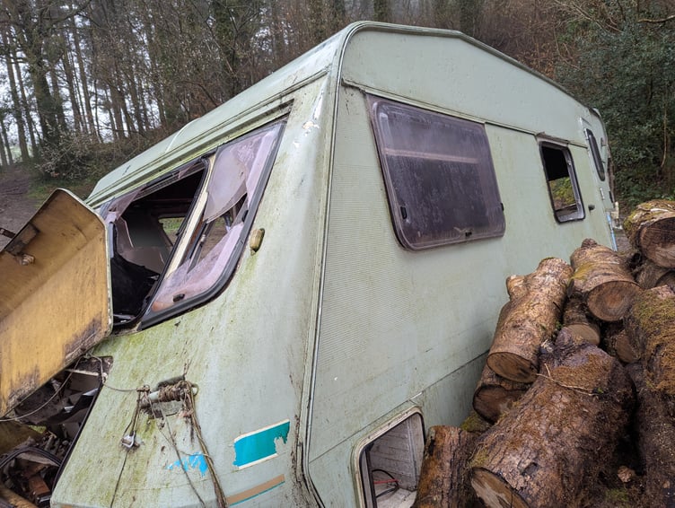 The caravan appears to have been pushed into a log pile.