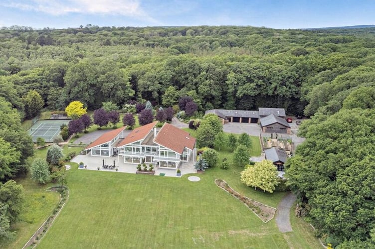 This luxury mansion with an entirely glass exterior is on sale for £4 million- with its own tennis courts and helicopter pad. A five-bedroom house within 20 acres of its own woodland on the Surrey and Sussex border has hit the market which has a striking glass exterior. The gardens of the property in Billingshurst, West Sussex, feature a three-acre lake with rainbow trout, a fishing pontoon, a workshop, a dehumidified multi?car garage, and a cottage. There is also an unrestricted helipad, and an air conditioned storage hanger to keep your helicopter in- which doubles as a golf simulator.