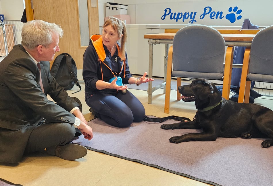 <p>East Hampshire MP Damian Hinds learns about Dogs for Autism’s training of black Labrador Hobson.</p>