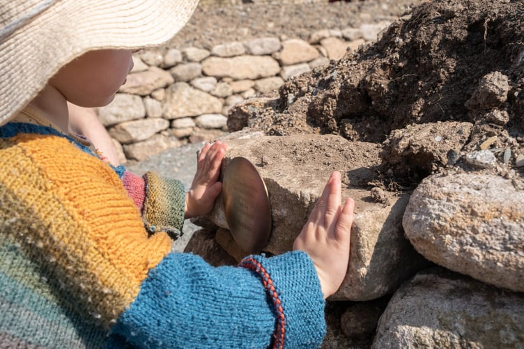 Three-year-old Bryher Tagney lays the last stone at Kerdroya