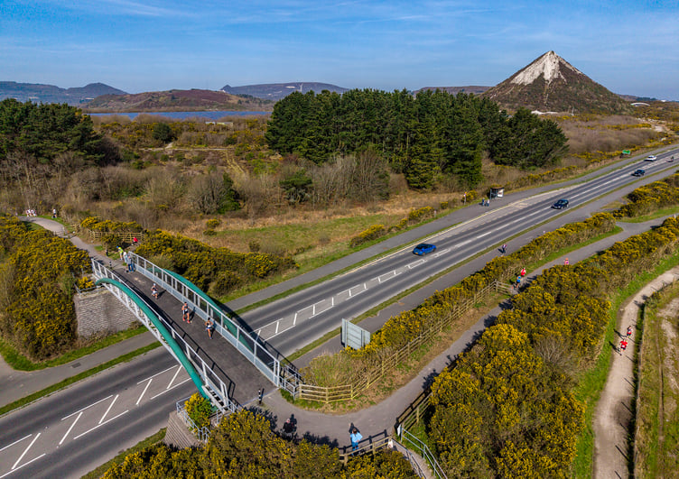 Runners cross the footbridge on the A391 with the Skytip in the background. (Picture: Paul Williams)