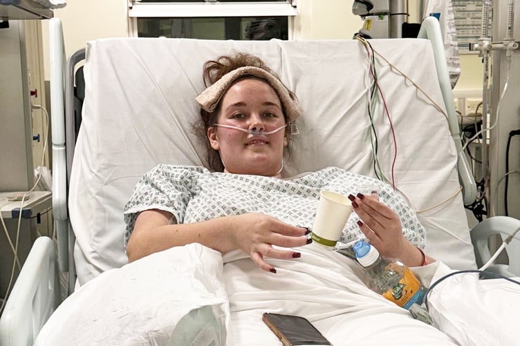 Jess Gibelli in hospital. // A young woman's stomach bug and bloating turned out to be a rare and aggressive form of blood cancer. Jess Gibelli, 28, started experiencing nausea, sickness, severe fatigue and bloating in November 2025 but she initially put it down to a sickness bug. She was working two physically demanding jobs as a florist and running her own event décor business - Viva La Fiesta - and she'd go straight to bed after work without having any dinner. But when her heart rate suddenly shot up to 160 while lying down in December 2025, Jess was rushed to hospital and doctors found a 30cm abdominal mass on an ultrasound.