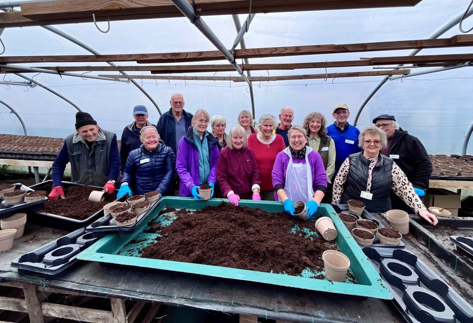 <p>Farnham volunteers filling pots.</p>
