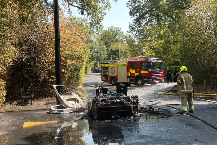 Surrey Fire and Rescue putting out burnt car on Thursley Road in Elstead