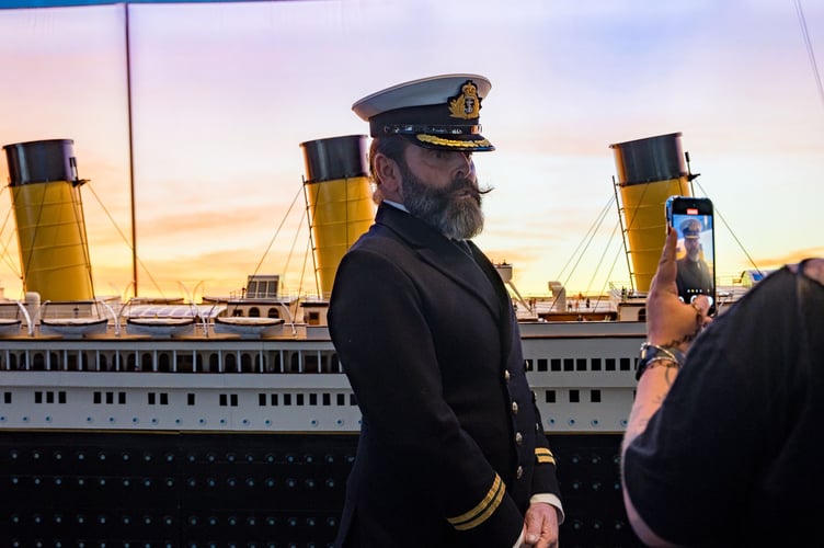 A Captain Edward Smith lookalike alongside the replica of the Titanic.
